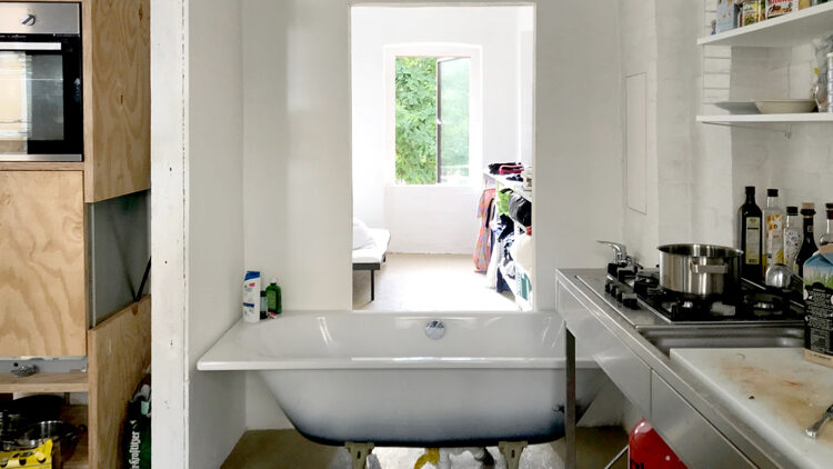 © SUMMACUMFEMMER Blick aus einer offenen Küche in ein weiteres Zimmer