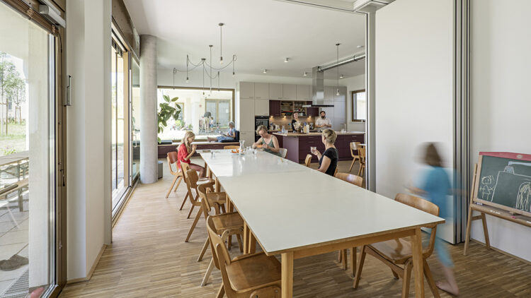 © Hertha Hurnaus An einem langen Tisch sitzen mehrere Menschen