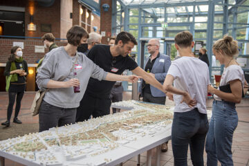 © IBA Hamburg / Bente Stachowske Menschen stehen um ein Modell von Wilhelmsburg