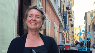 Podcast-Gästin Dr. Anke Schröder sitzt an einem Tisch in einer kleinen Gasse.
