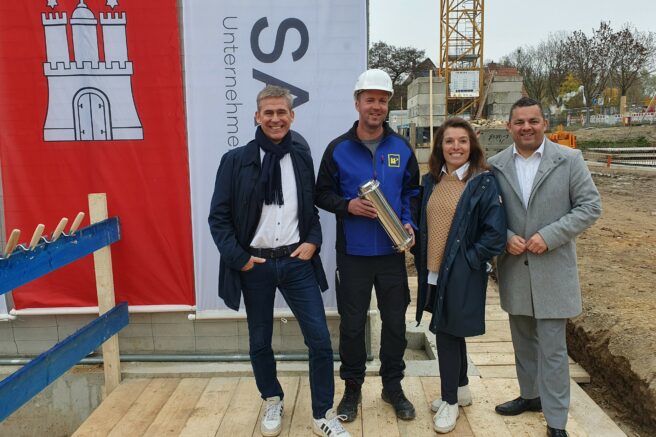 © IBA Hamburg / Arne von Maydell Gruppenbild auf der Baustelle: Kay Gätgens mit Vertreter:innen der Baufirma, SAGA und Bezirksamtsleiter Hamburg-Mitte Ralf Neubauer