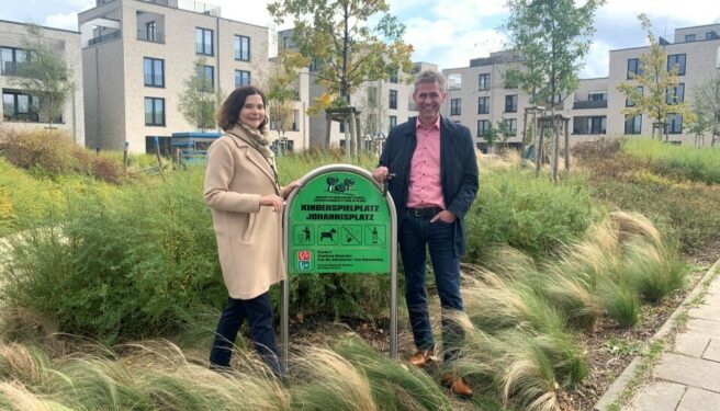 © IBA Hamburg / Arne von Maydell Sophie Fredenhagen und Kay Gätgens mit dem Hinweisschid zum Platz Johannisplatz im Vogelkamp Neugraben