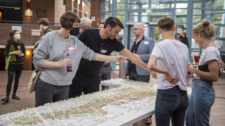 © IBA Hamburg / Bente Stachowske Menschen stehen um ein Modell von Wilhelmsburg