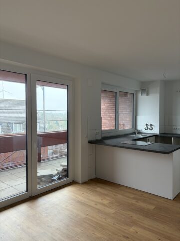 © IBA Hamburg Innenansicht einer bezugsfertigen Wohnung mit großen Fenstern und Blick in eine offene Küche