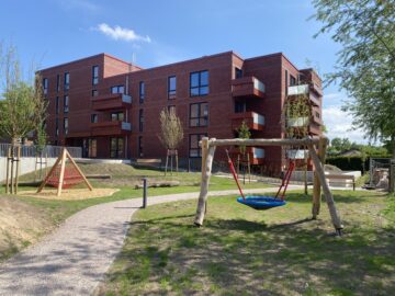 © IBA Hamburg Spielplatz mit Schaukel und Wegen vor den SAGA-Wohngebäuden
