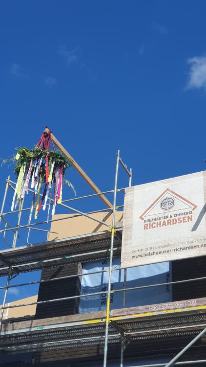 © IBA Hamburg Eine bunte Richtfestkrone flattert vor blauem Himmel