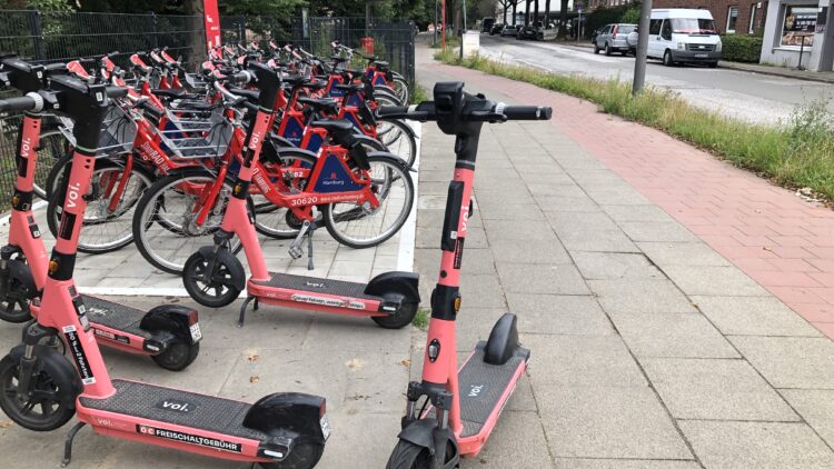 © IBA Hamburg / Henrike Warning Aktuelle Aufnahme der StadtRAD-Station mit zahlreichen Leihfahrrädern und mehreren E-Scootern an der Bushaltestelle „Rahmwerder Straße“.