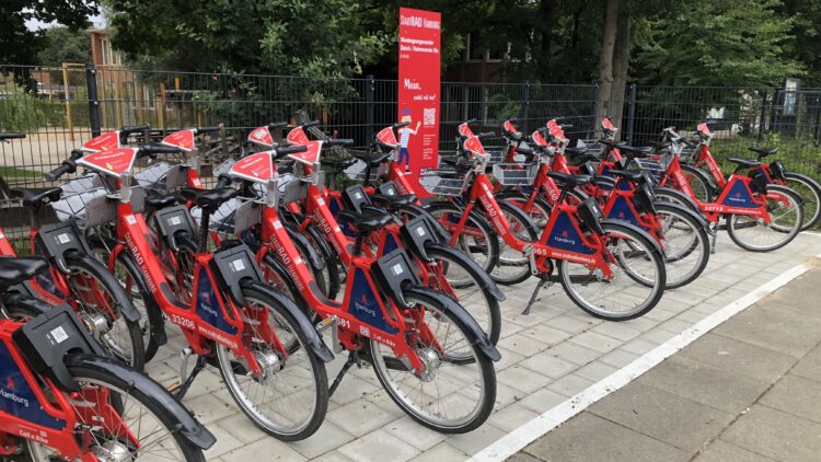 © IBA Hamburg / Henrike Warning Aktuelle Aufnahme der StadtRAD-Station „Niedergeorgswerder Deich / Rahmwerder Straße“ mit vielen verfügbaren Leihfahrrädern am Quartiersplatz in Georgswerder.