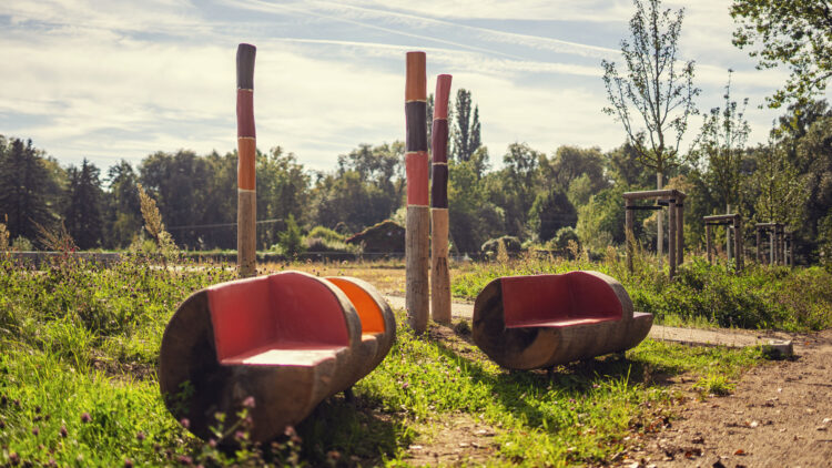 © Marcus Barthel Bunter, baumstammförmiger Freisitzbereich und farbig bemalte Holzpfähle
