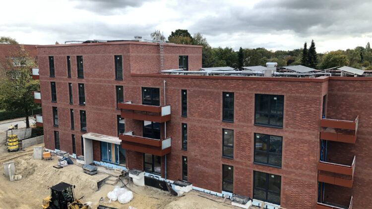 © IBA Hamburg Baustelle eines mehrgeschssigen Hauses, davor eine Baumaschne