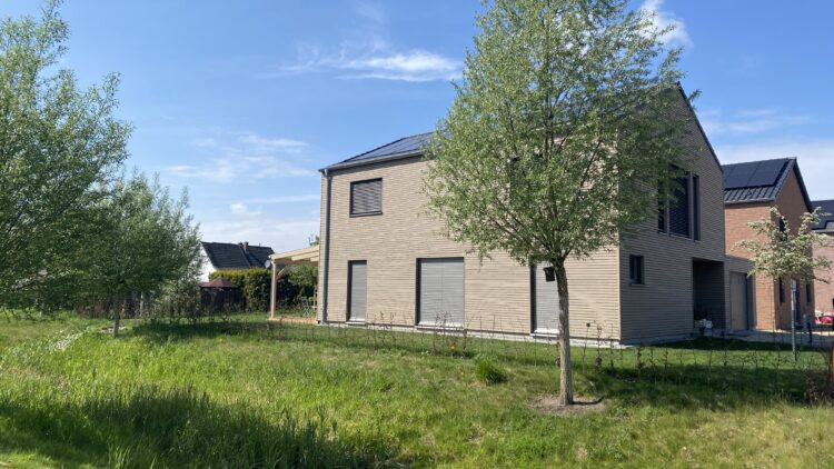 © IBA Hamburg Einfamilienhaus mit Gartenfläche und junger Bepflanzung im neuen Wohngebiet