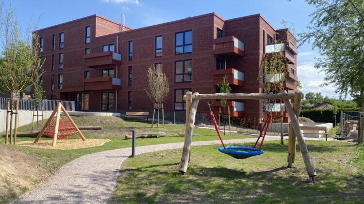 © IBA Hamburg Spielplatz mit Schaukel und Wegen vor den SAGA-Wohngebäuden