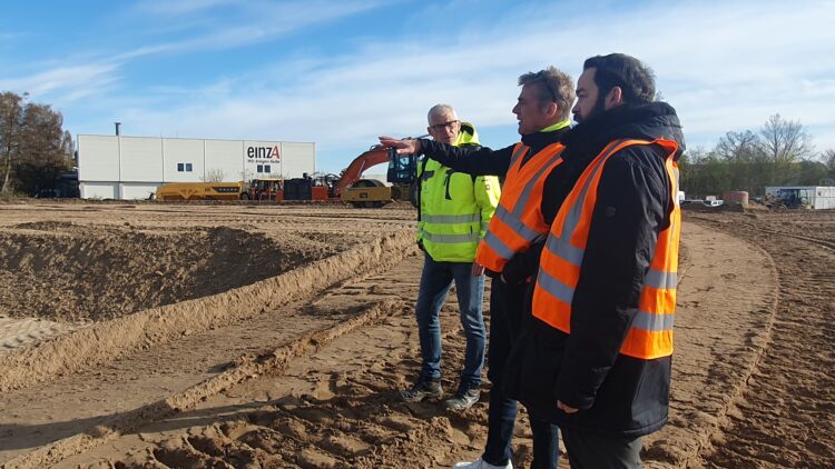 © IBA Hamburg / Arne von Maydell Der IBA-Geschäftsführer sowie zwei IBA-Kollegen stehen in Warnwesten auf der Baustelle und besprechen sich.