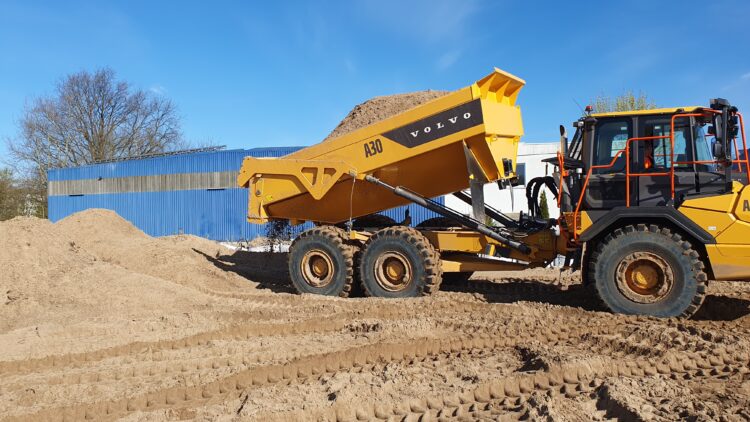 © IBA Hamburg / Arne von Maydell Ein Kipplaster kippt Sand auf der Baustelle ab.