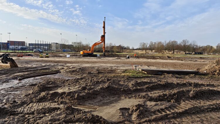 © IBA Hamburg Große Sandfläche auf einer Baustelle, im Hintergrund eine hohe Baumaschine