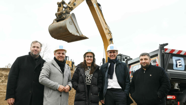 © IBA Hamburg / Andreas Fromm fünf Personen posieren für die Presse, im Hintergrund eine Baggerschaufel