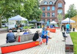 © IBA Hamburg Menschen in kleinen Gruppen auf einem Quartiersplatz