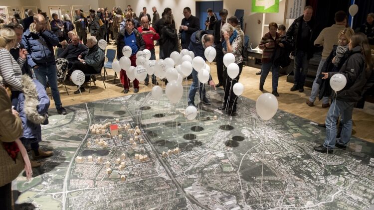 IBA Hamburg / Bente Stachowske Menschengruppe auf Stadtteilplan stehend