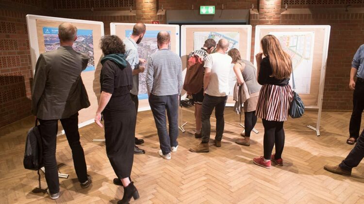 © IBA Hamburg GmbH / Jo Larsson Menschen stehen vor Stellwänden mit Postern