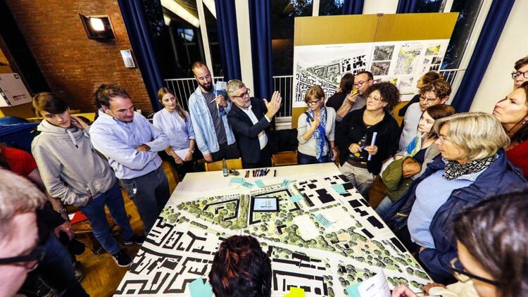 © IBA Hamburg GmbH / Jo Larsson Menschen stehen um einen Tisch, auf dem ein Plan liegt