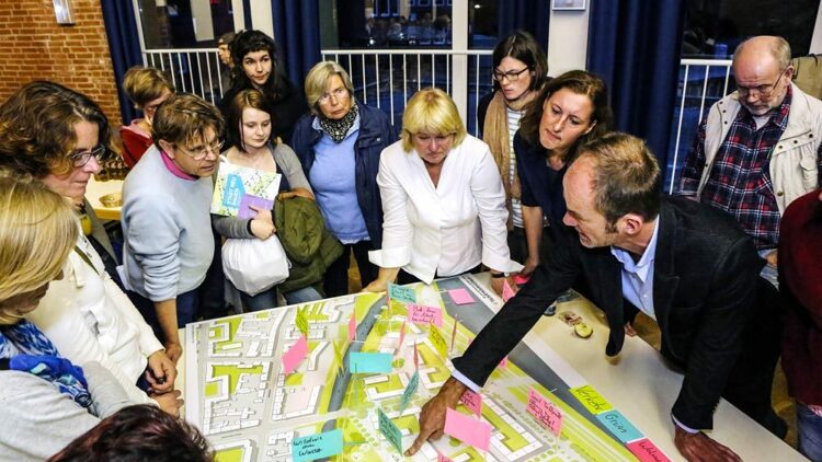 © IBA Hamburg / Anya Zuchold Menschen stehen um einen Tisch, auf dem ein Plan liegt